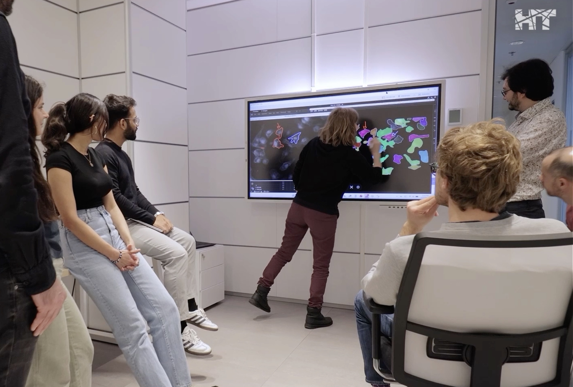Members of the MAIAS team at HT around a shared screen, discussing an AI-generated cell segmentation